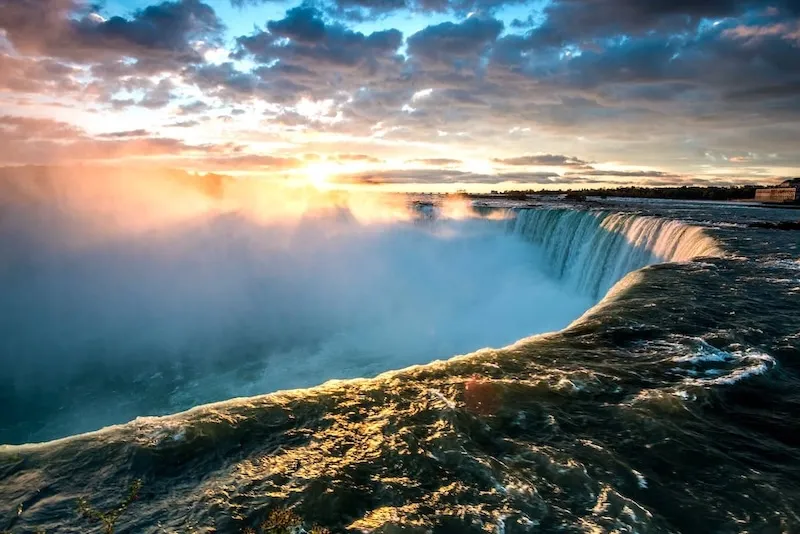 Tourists on Maid of the Mist boat enjoying Niagara Falls in summer